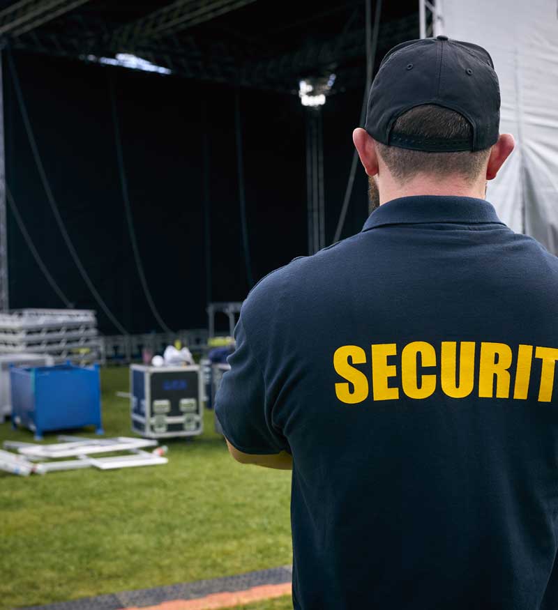 Close up of male security guard overseeing event setup.